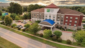 A Holiday Inn Express & Suites hotel with a parking lot, a covered entrance, and a view of the surrounding area. - Holiday Inn Express and Suites Springfield Medical District by IHG (Springfield)
