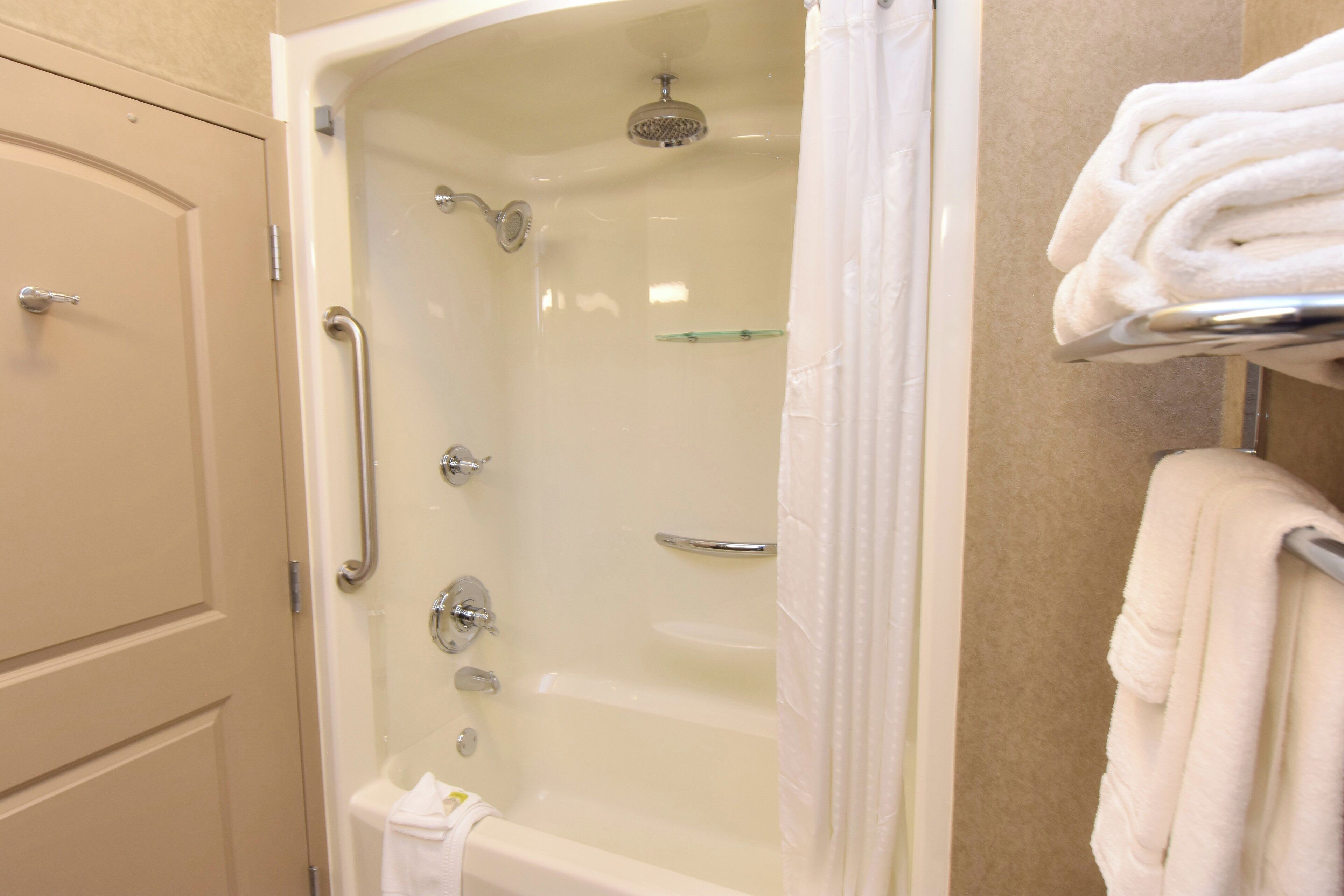 A bathroom with a bathtub, shower, and toilet.