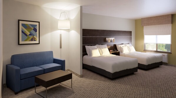 A hotel room with a blue sofa, two single beds, a nightstand, a lamp, and a framed picture on the wall. - Holiday Inn Express and Suites Springfield Medical District by IHG (Springfield)