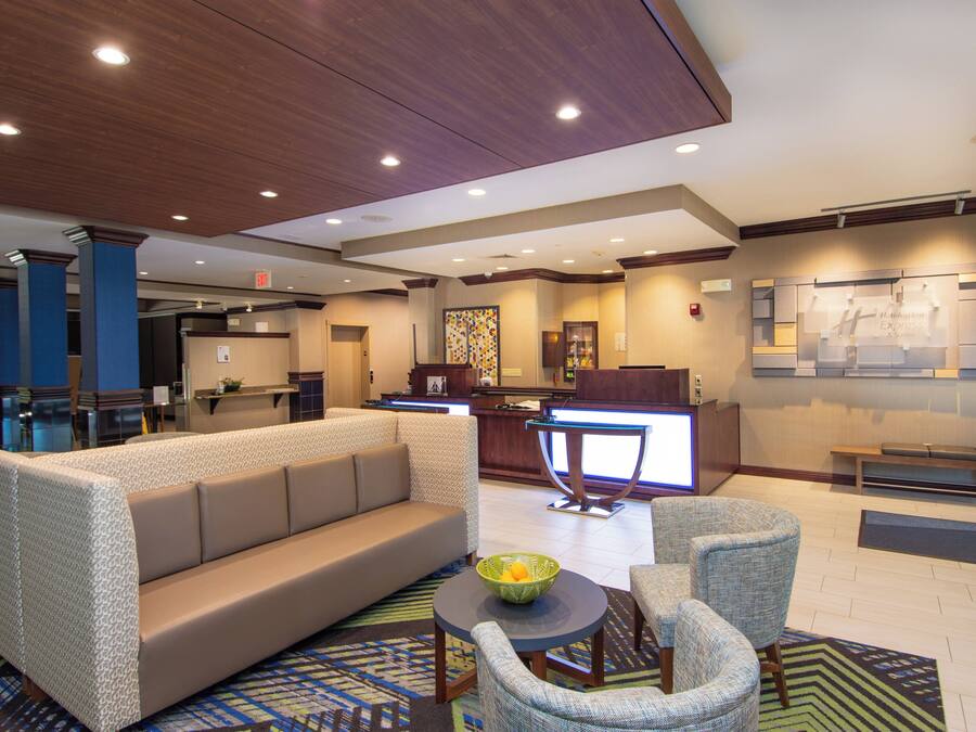 A hotel lobby with a reception desk, a sofa, and a seating area.