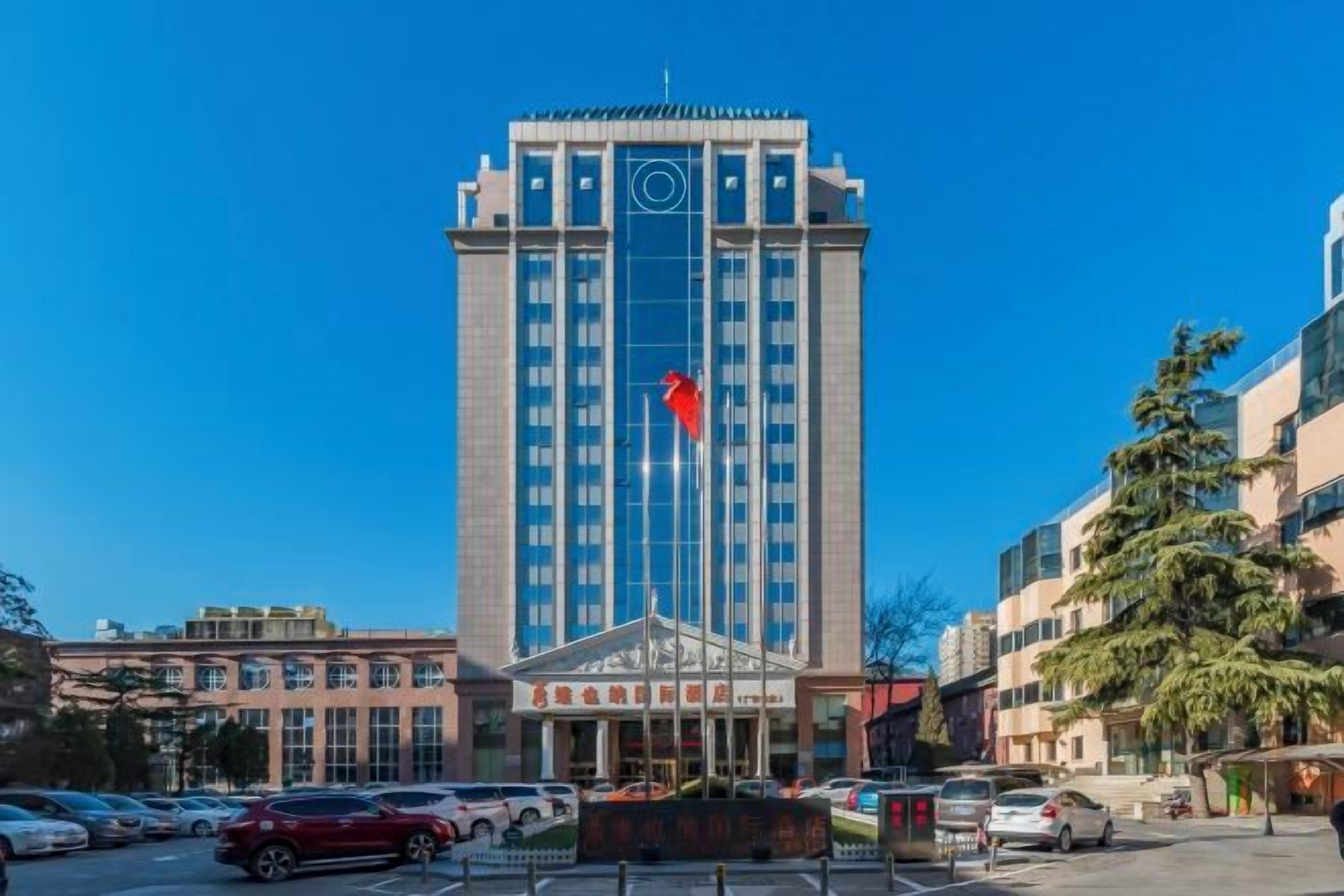 A tall hotel with a central entrance, multiple floors, and a flag on top.