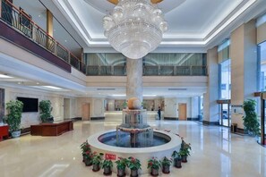 A spacious lobby with a central fountain, multiple floors, and a balcony. - Vienna International Hotel (Beijing Niujie Guang'anmennei Subway Station Branch) (Beijing)
