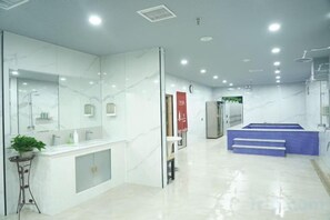Une salle de bain moderne avec un grand miroir, une baignoire et un lavabo.