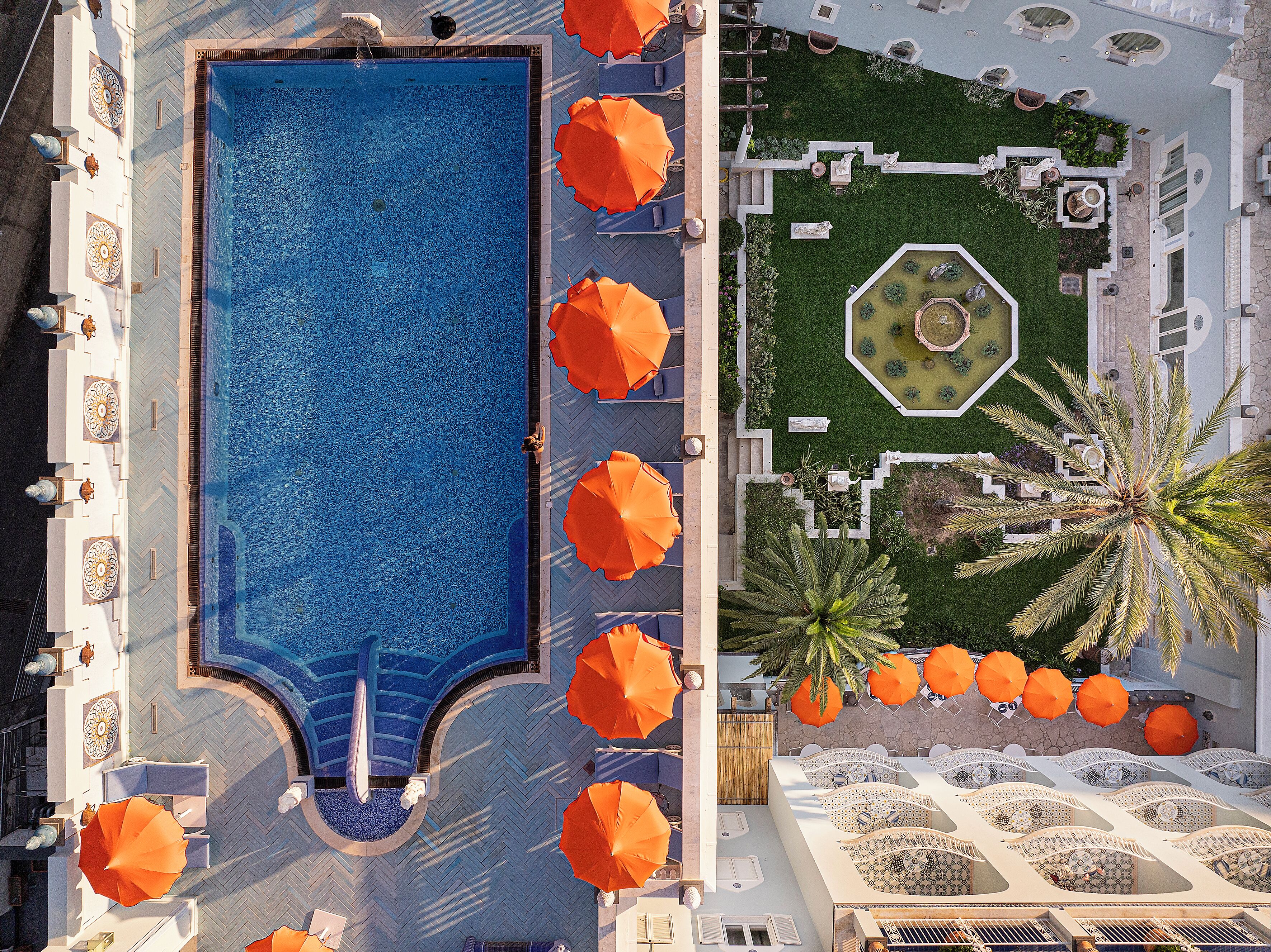 Una piscina cubierta, una piscina al aire libre, sombrillas