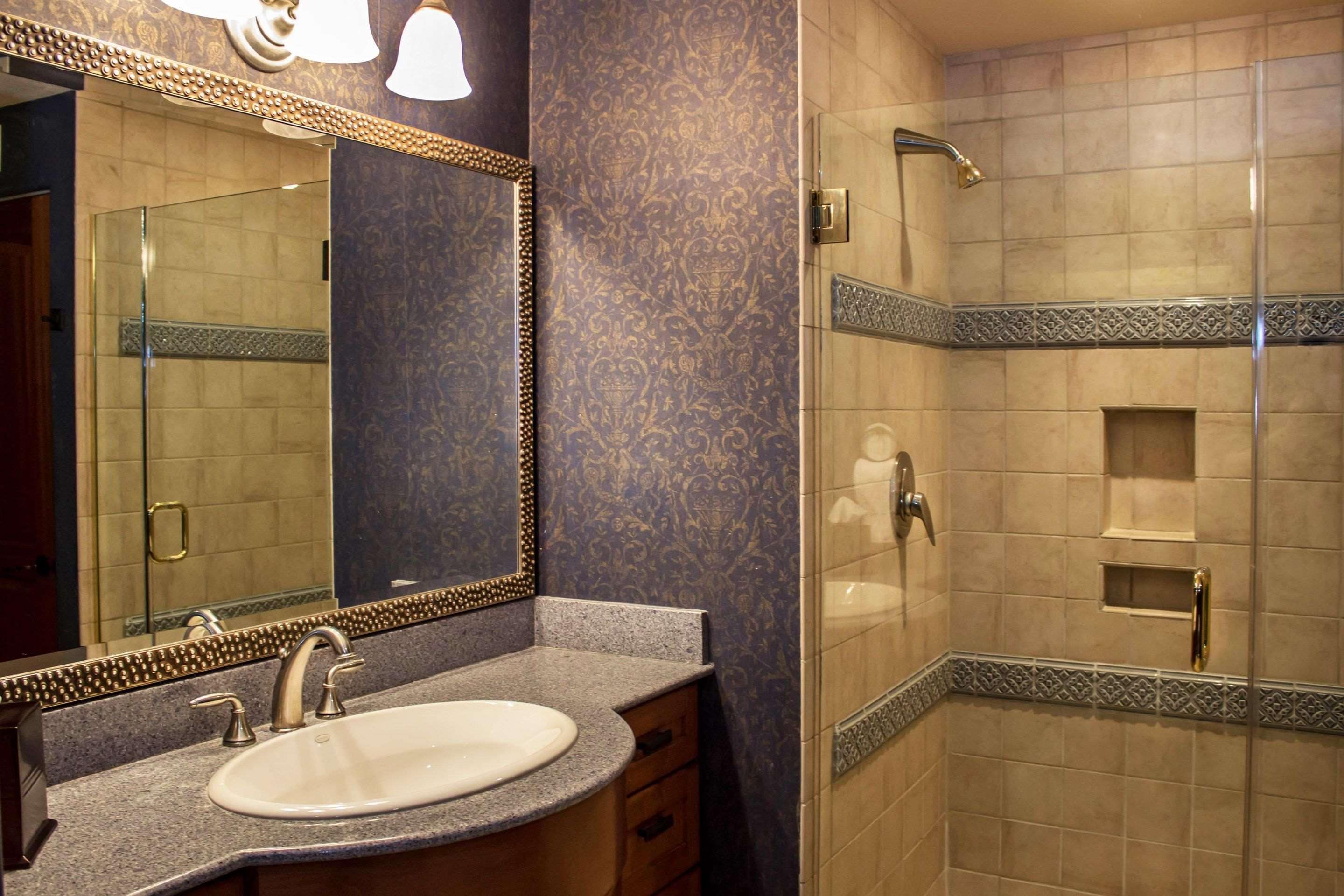 Une salle de bain avec un lavabo, un miroir et une douche.