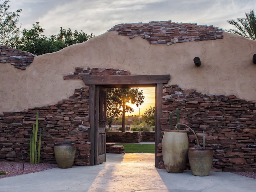A building with a stone facade, a wooden door, and large planters.
