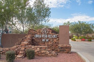 A sign for Cibola Vista Resort and Spa with a stone wall backdrop.