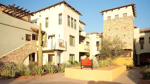 A multi-story building with a stone facade, a cactus in the foreground, and a sign indicating 'City of Arches'.