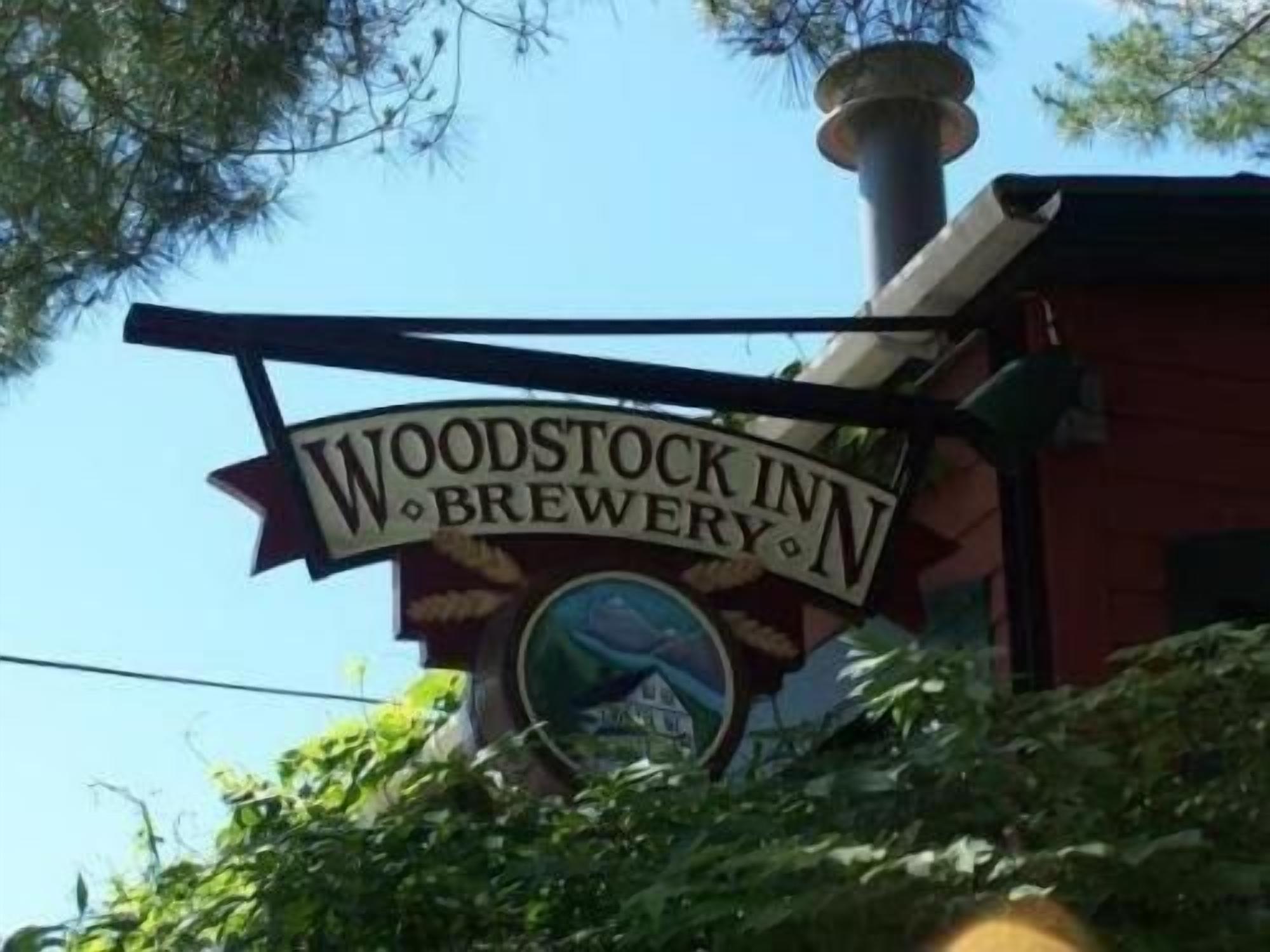 Letrero de la Cervecería Woodstock Inn con un diseño rústico y una chimenea.