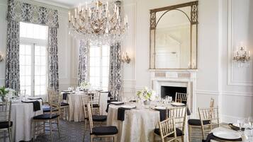 Una sala de dinar elegant amb lluminàries penjants, una llar de foc i un gran mirall.