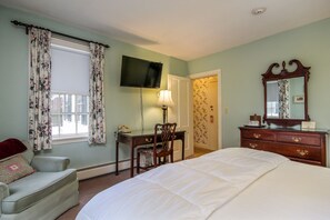 A bedroom with a bed, a desk, a chair, a dresser, a television, and a window with curtains. - The Inn at Montpelier (Montpelier)