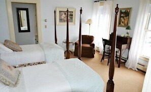 A hotel room with two single beds, a desk, a chair, and a painting on the wall. - The Inn at Montpelier (Montpelier)