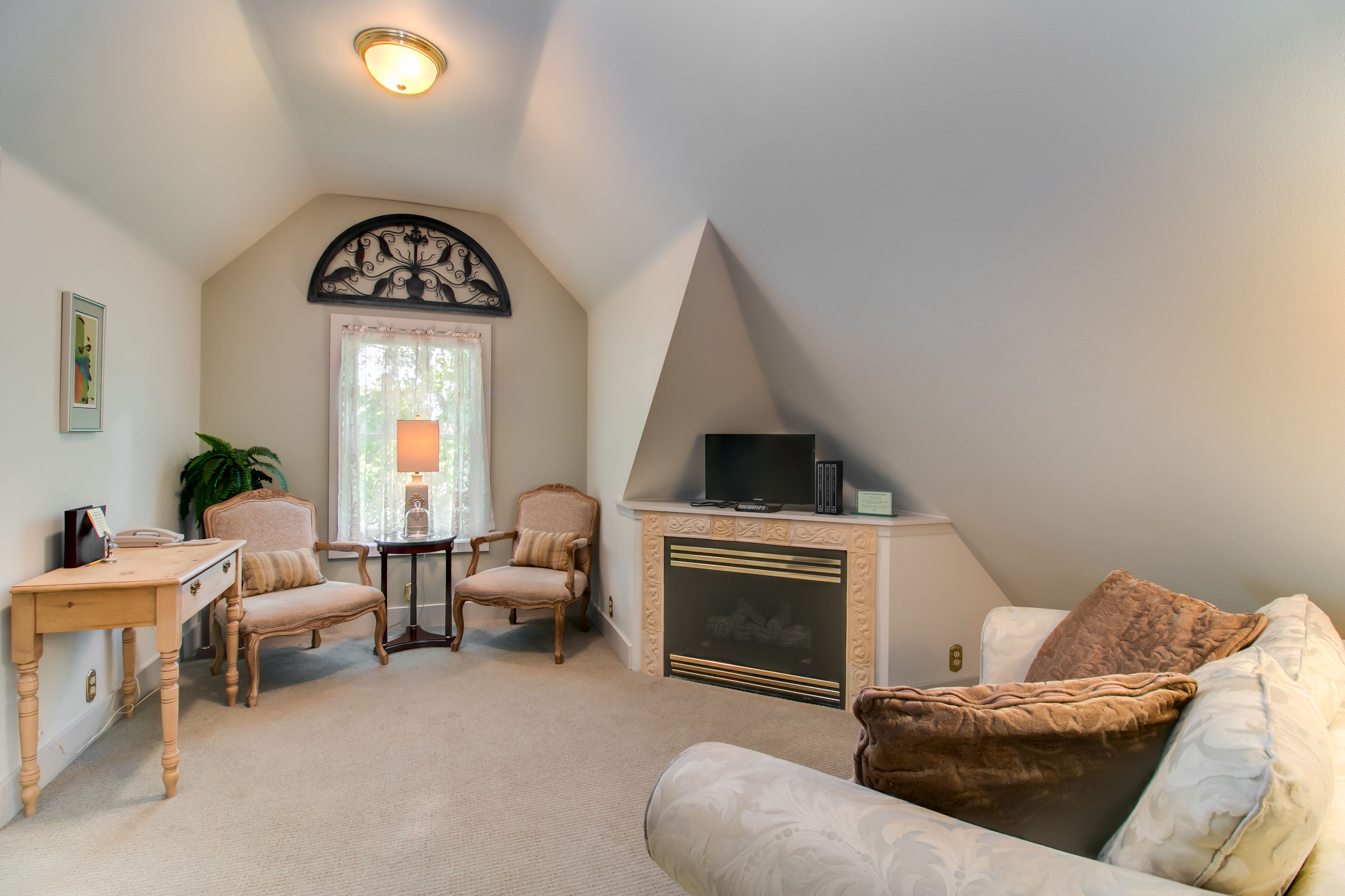 A cozy living room with a fireplace, a television, and comfortable seating.
