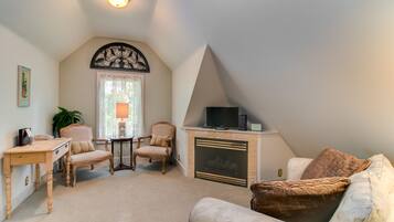 A cozy living room with a fireplace, a television, and comfortable seating.