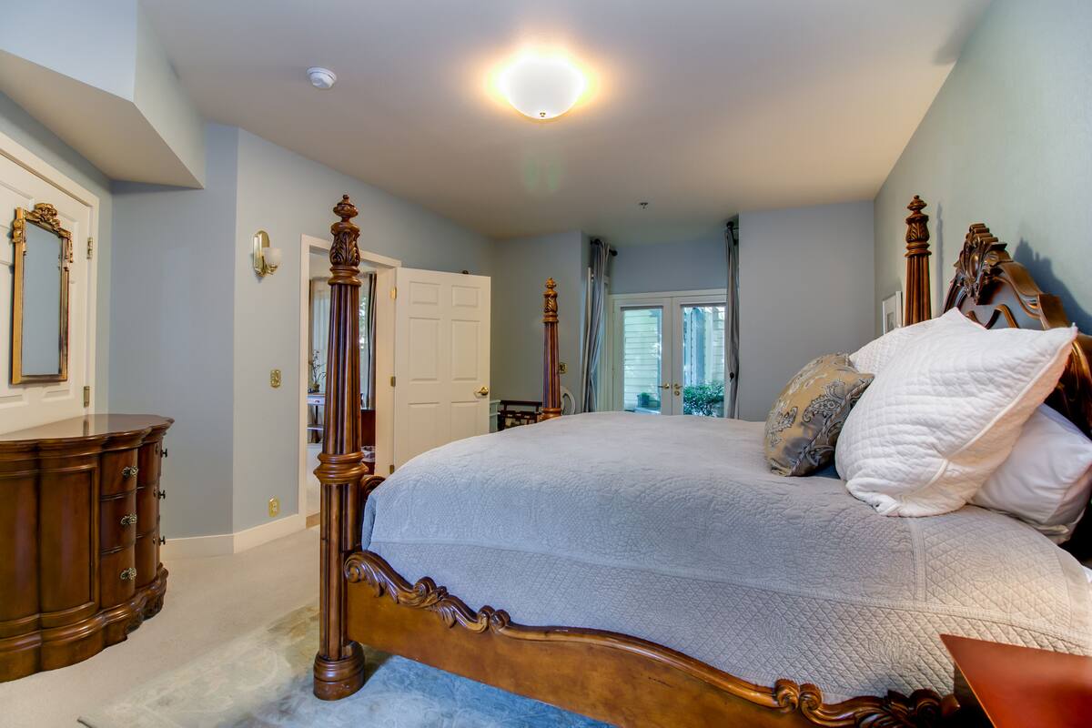 Un dormitorio con una cama grande, muebles de madera y vista al exterior.