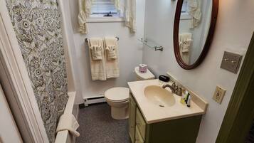 A compact bathroom with a toilet, sink, and mirror.