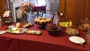 A buffet table with various food items and a decorative centerpiece. - Arlington Inn (Arlington)