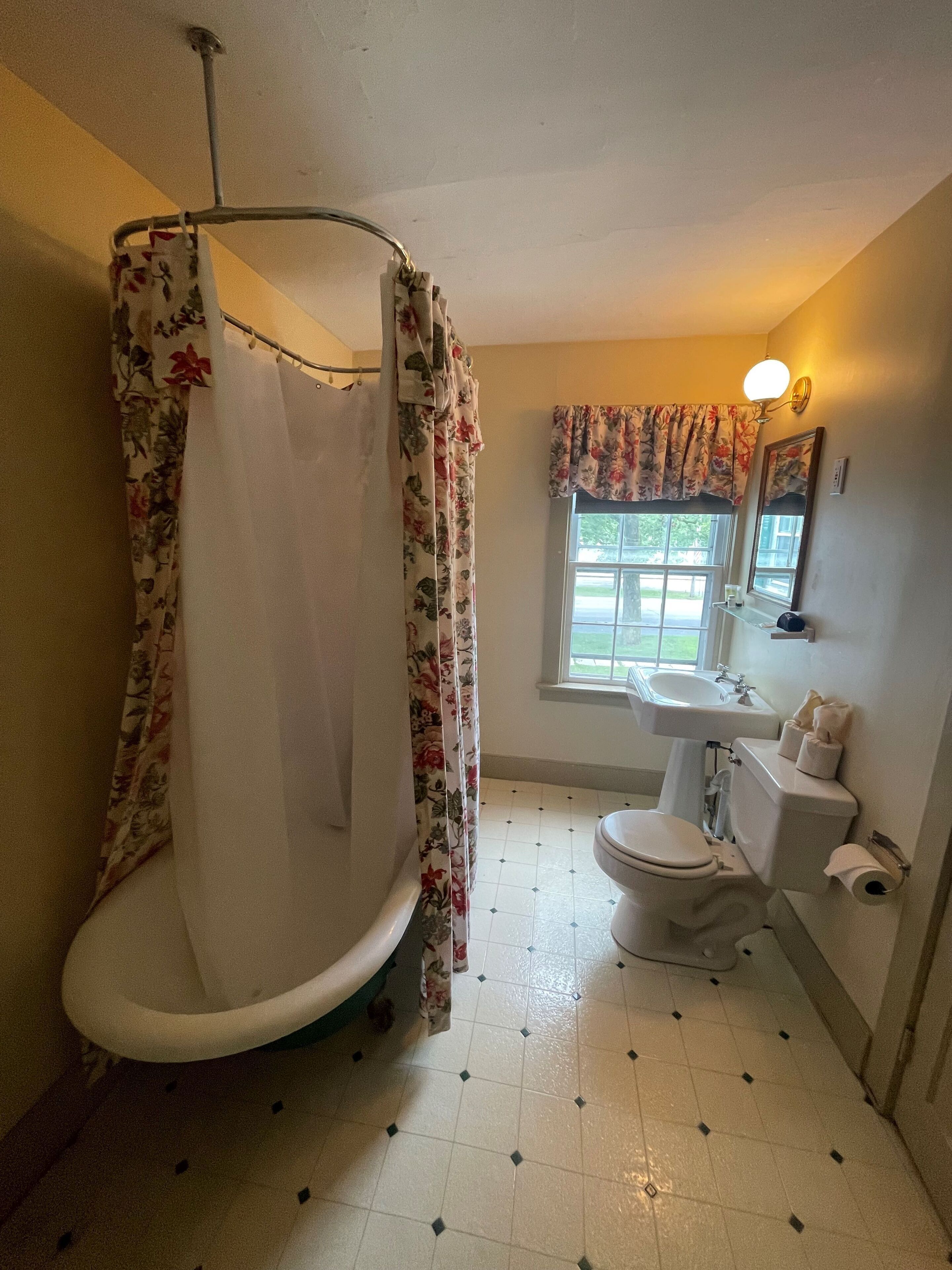 Baño con ducha, inodoro, lavamanos y ventana con vistas.