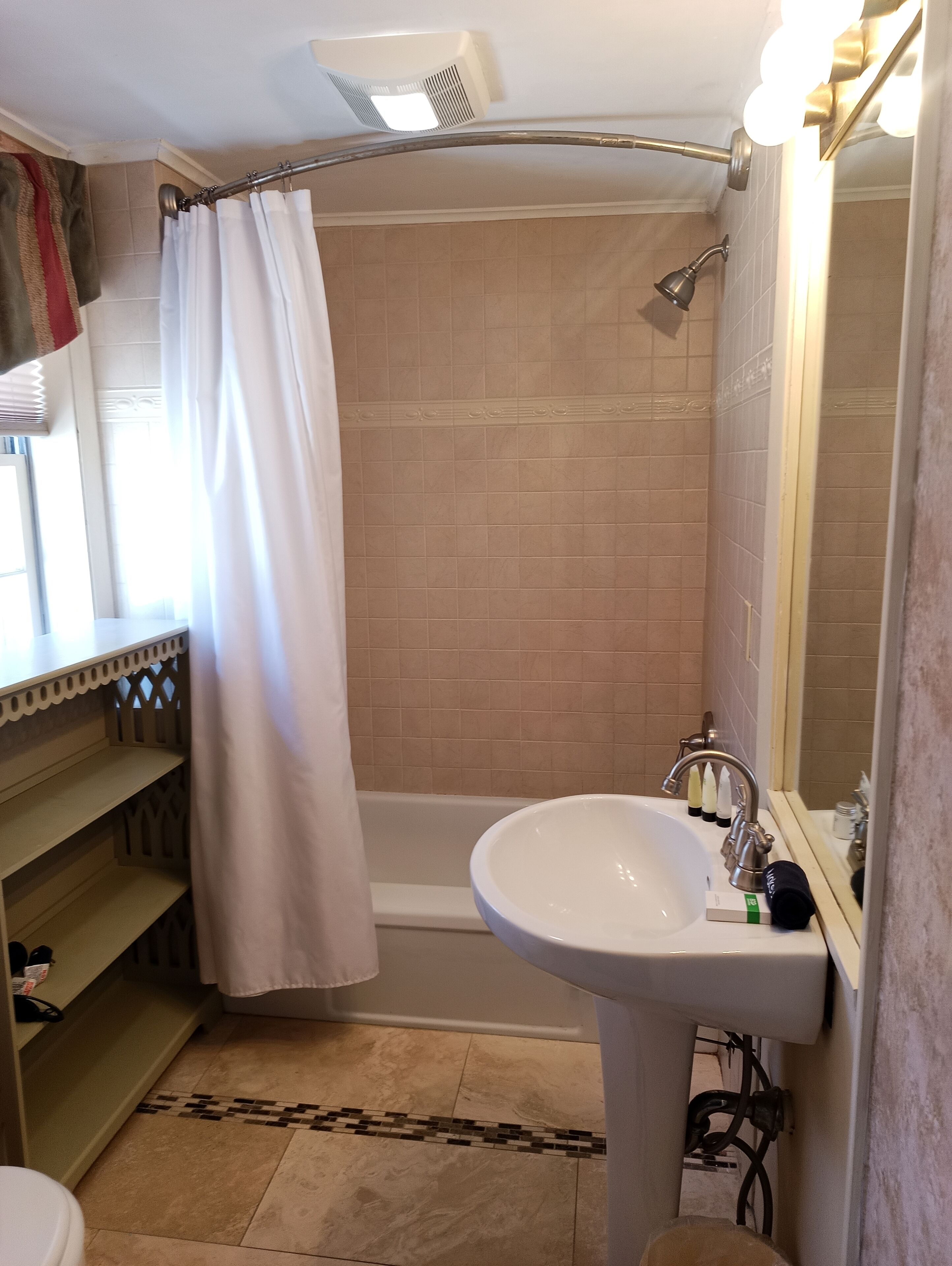 Une salle de bain avec une baignoire, un lavabo et un miroir.
