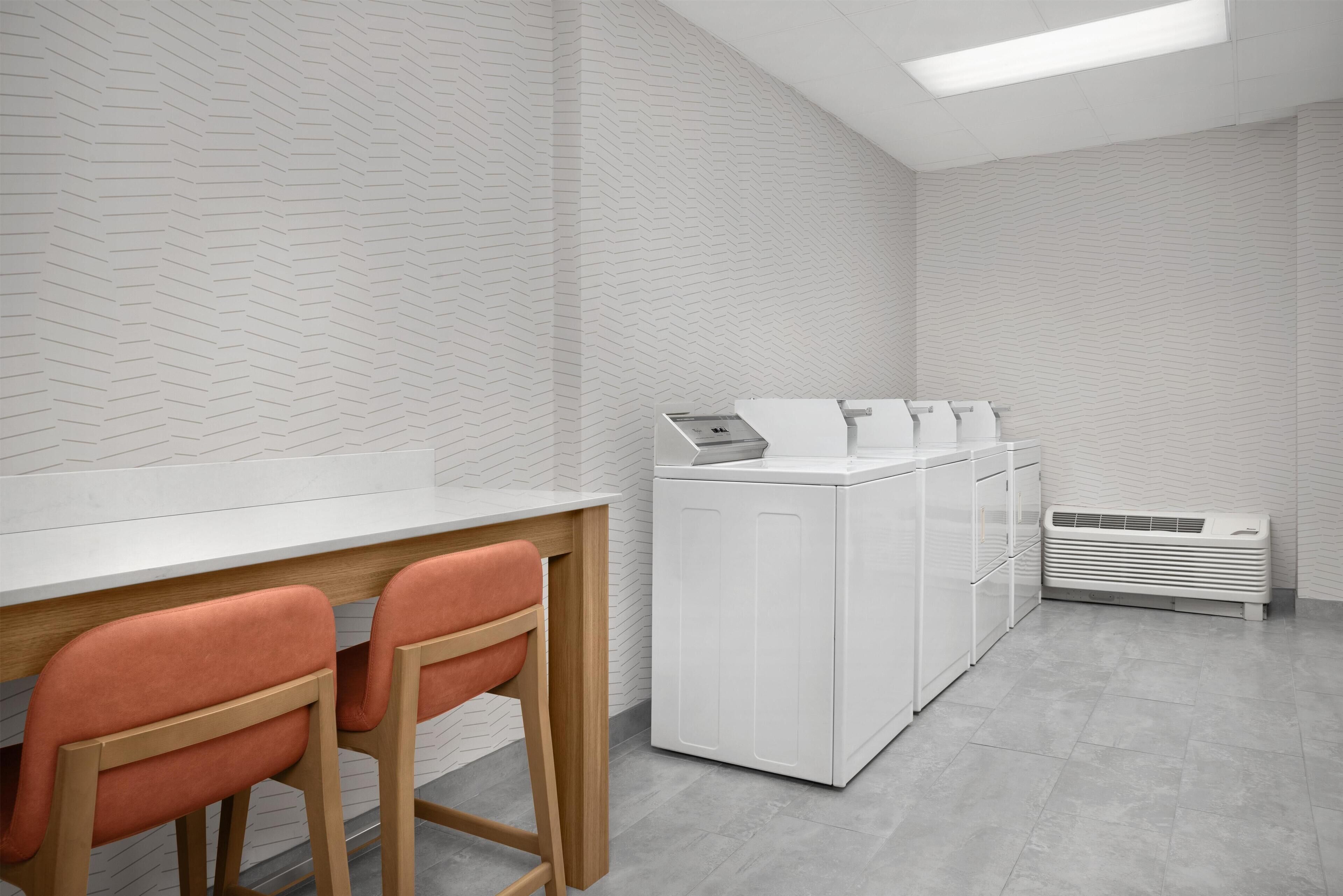 A modern kitchen with a white herringbone-patterned backsplash, a white countertop, and a built-in dishwasher.