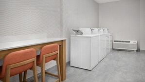 A modern kitchen with a white herringbone-patterned backsplash, a white countertop, and a built-in dishwasher. - Hampton Inn & Suites Lake City (Lake City)