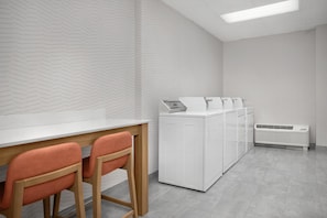 Eine moderne Küche mit weißem Fischgräten-Spritzschutz, einer weißen Arbeitsplatte und einem eingebauten Geschirrspüler.