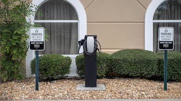 An EV charging station with two signs indicating it is for guest use only while charging.