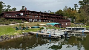 A multi-story lodge with outdoor seating and a dock by a pond. - St Croix Inn Solon Springs  (Solon Springs)