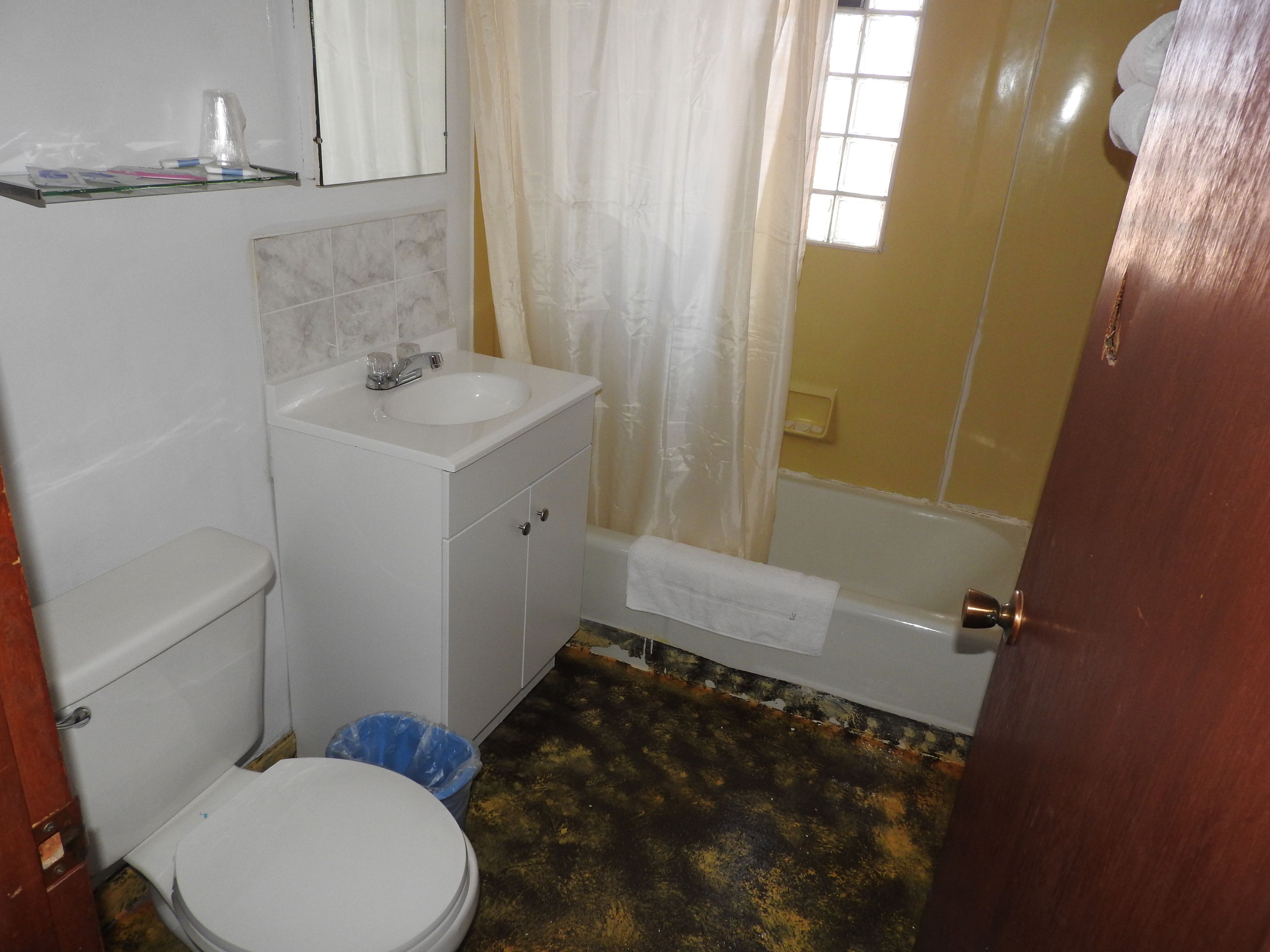 A bathroom with a toilet, sink, and bathtub.