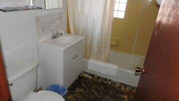 A bathroom with a toilet, sink, and bathtub.