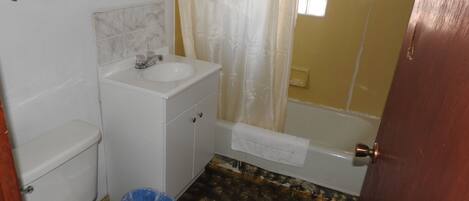 Un baño con inodoro, lavamanos y bañera.