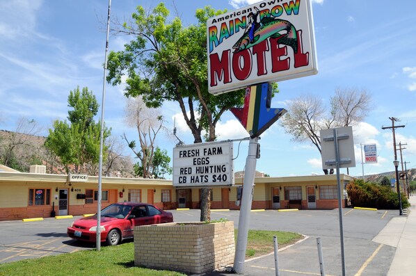 Un motel avec une enseigne publicitaire annonçant des œufs frais de la ferme, des vêtements de chasse rouge et des casquettes de radioamateur à 40 dollars.