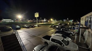 A parking lot at night with multiple vehicles and a sign indicating a Colonial Inn.