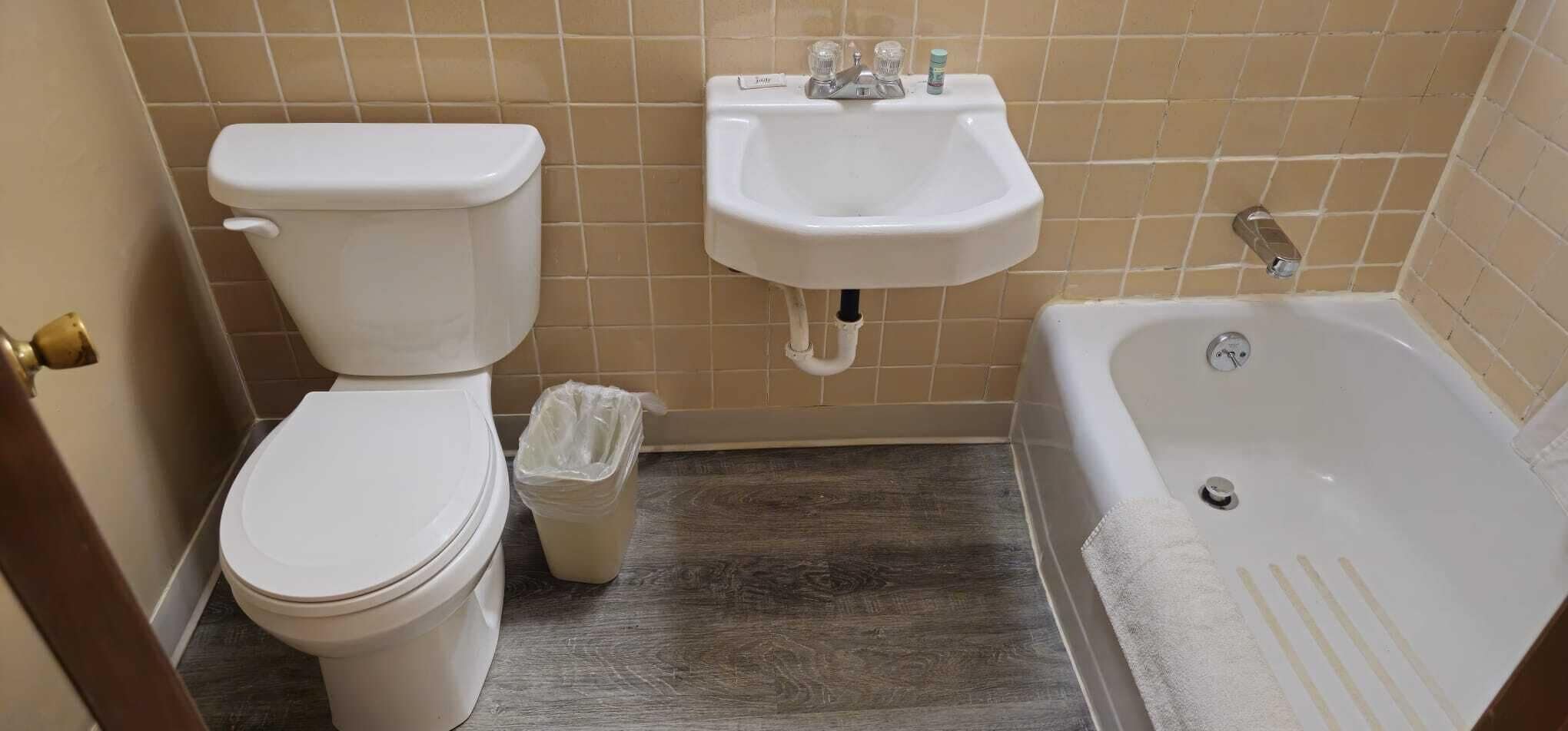Une salle de bain avec des toilettes, un lavabo et une baignoire.