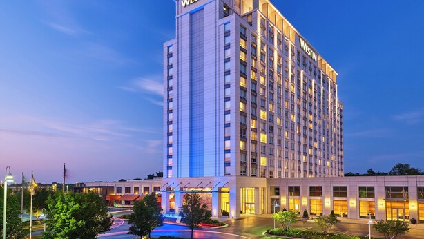 Un hotel de gran altura con un llamativo letrero 'WESTIN', varios pisos y una entrada bien iluminada.