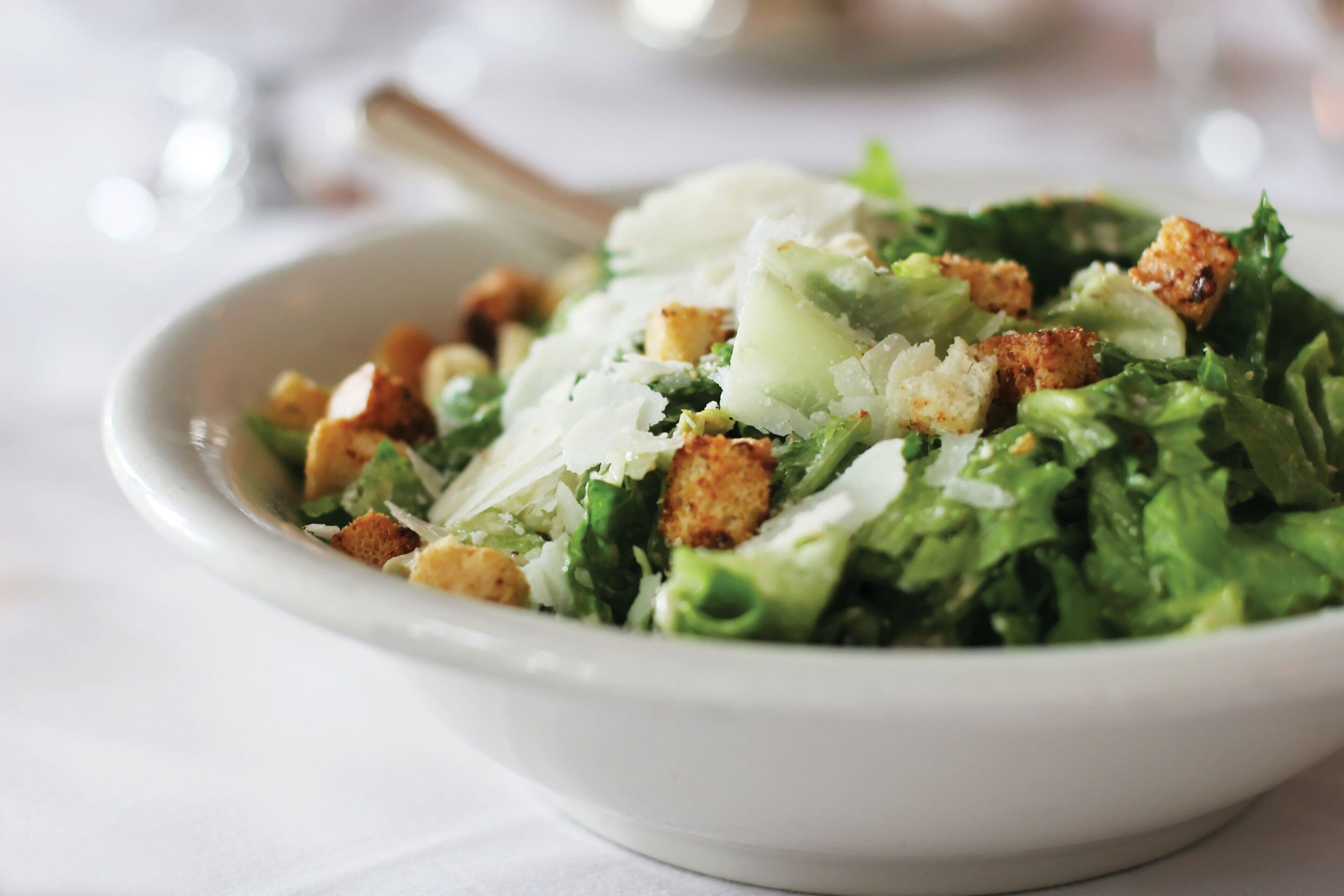 Ensalada con crutones y queso rallado.