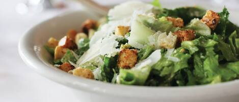 Ensalada con crutones y queso rallado.
