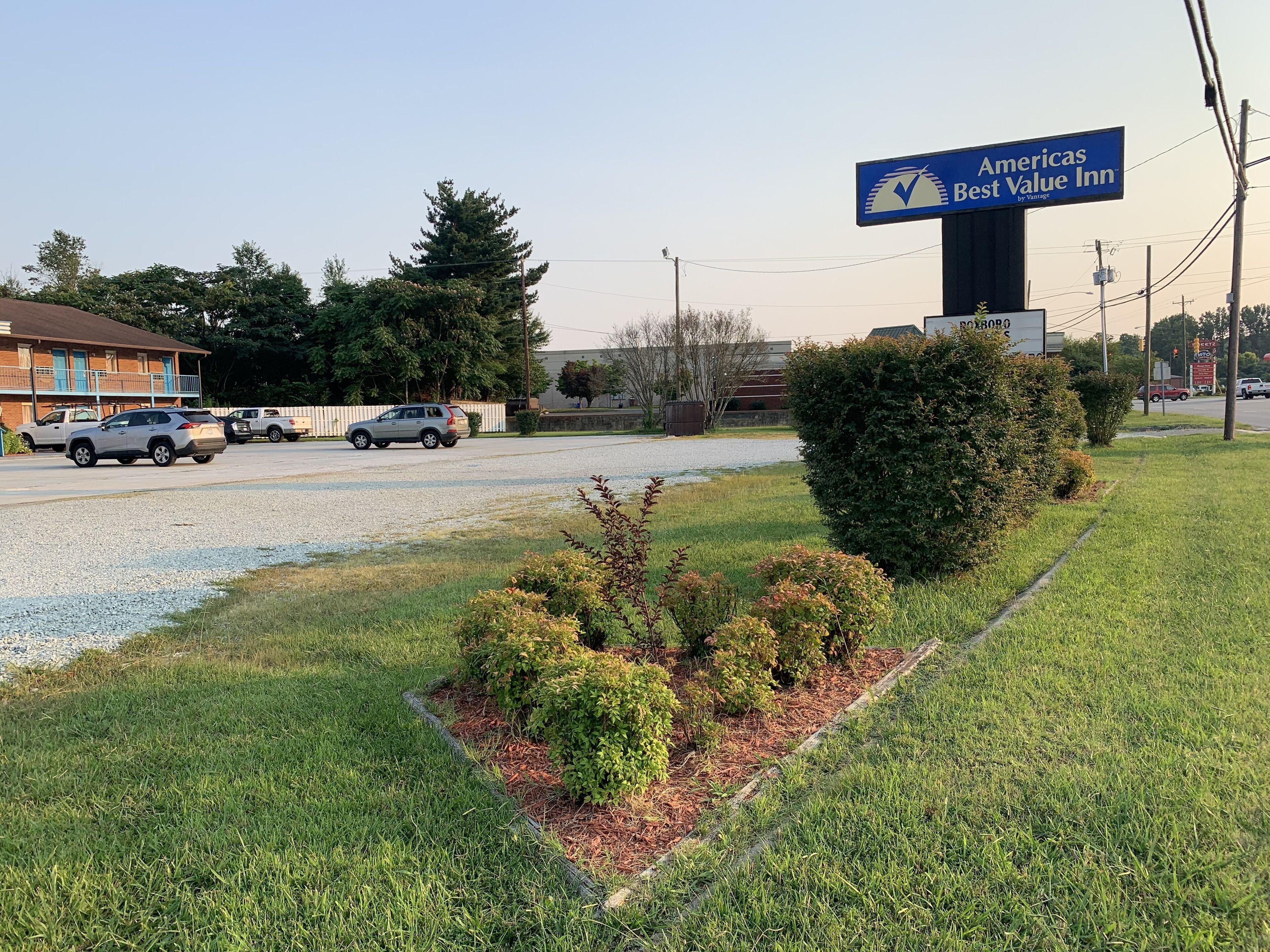 A parking area with a sign for Americas Best Value Inn by Vintage.