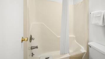 Een badkamer met een bad, toilet en douchegordijn.