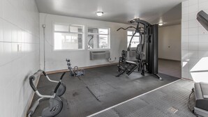 Una palestra con attrezzature per esercizi, una cyclette e una finestra vista esterna.
