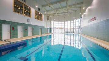 Relax by the pool surrounded by a clean and well-maintained space with a clear view of the water.