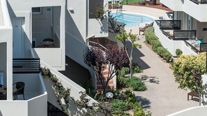 A modern hotel with a pool, outdoor seating, and a view of the sea. - Corinna Mare (Chania)
