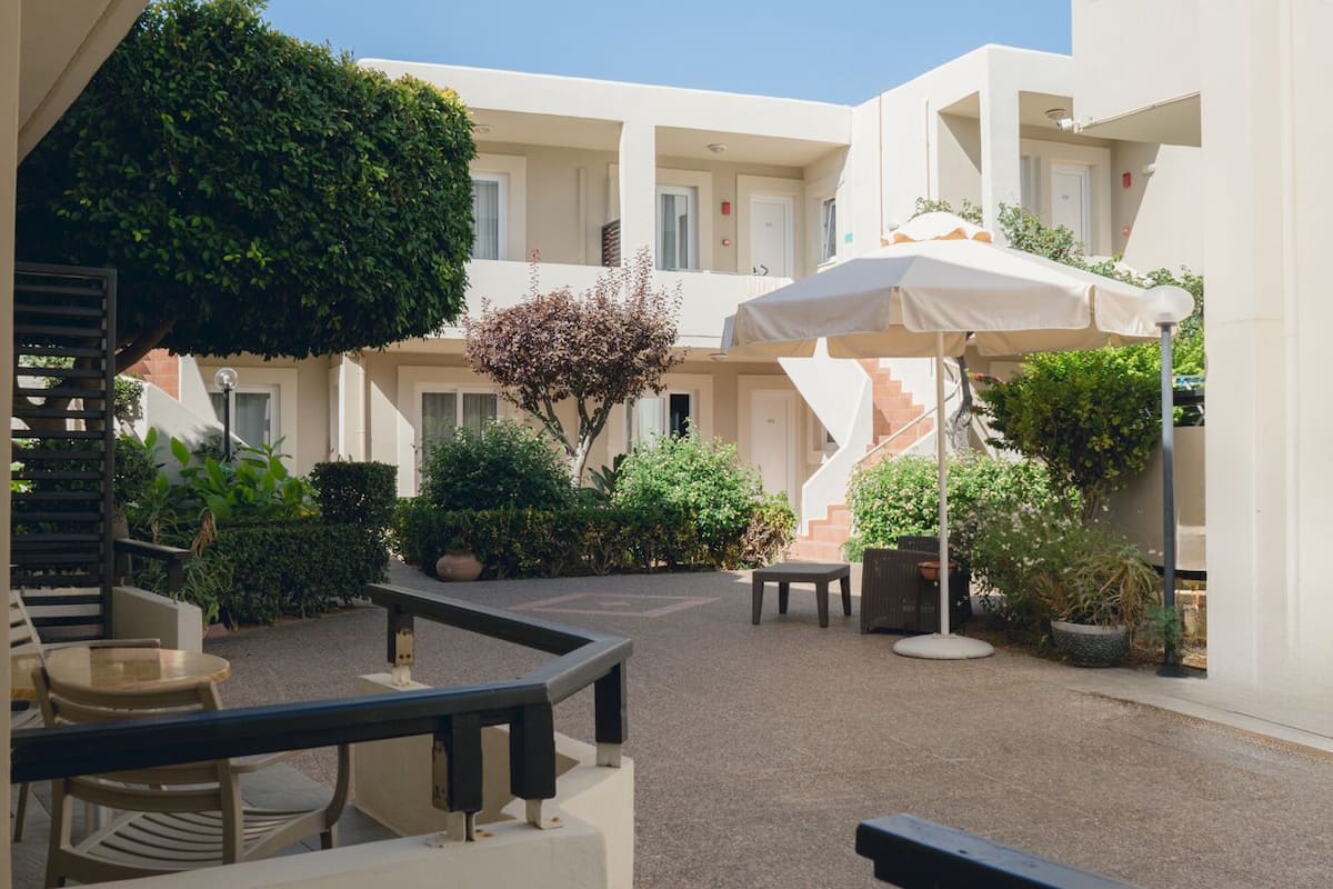 A courtyard with outdoor seating, a staircase, and a view of the surrounding buildings.