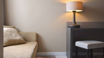 A modern room with a sofa, a small table, and a lamp.