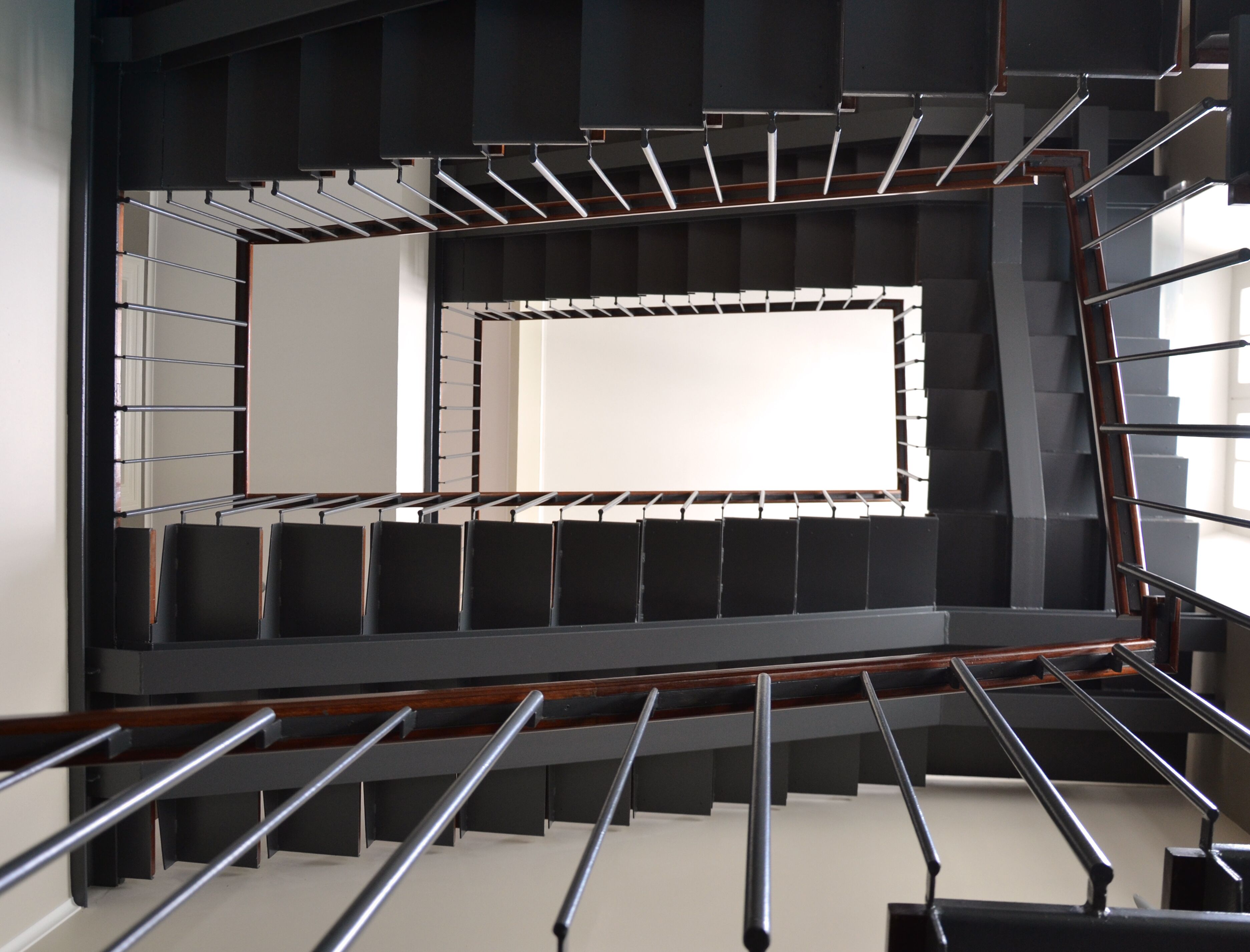 Una escalera moderna con barandillas de metal y peldaños de madera.