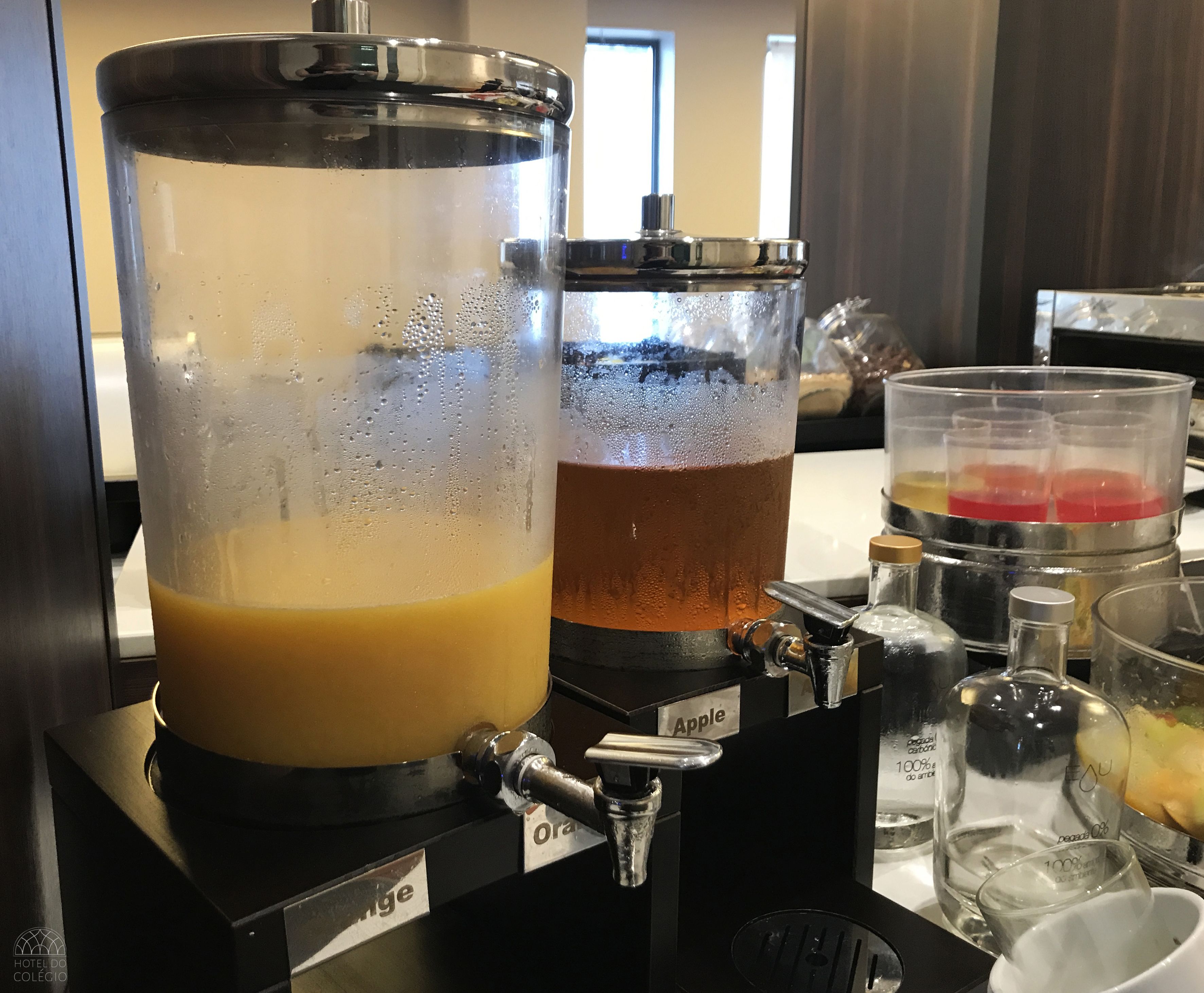 A beverage dispenser with two containers labeled "Orange" and "Apple."