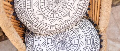 Una silla de mimbre con cojines estampados.