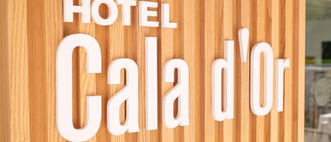 Un panel de madera con el texto "HOTEL Cala d'Or" en letras blancas.