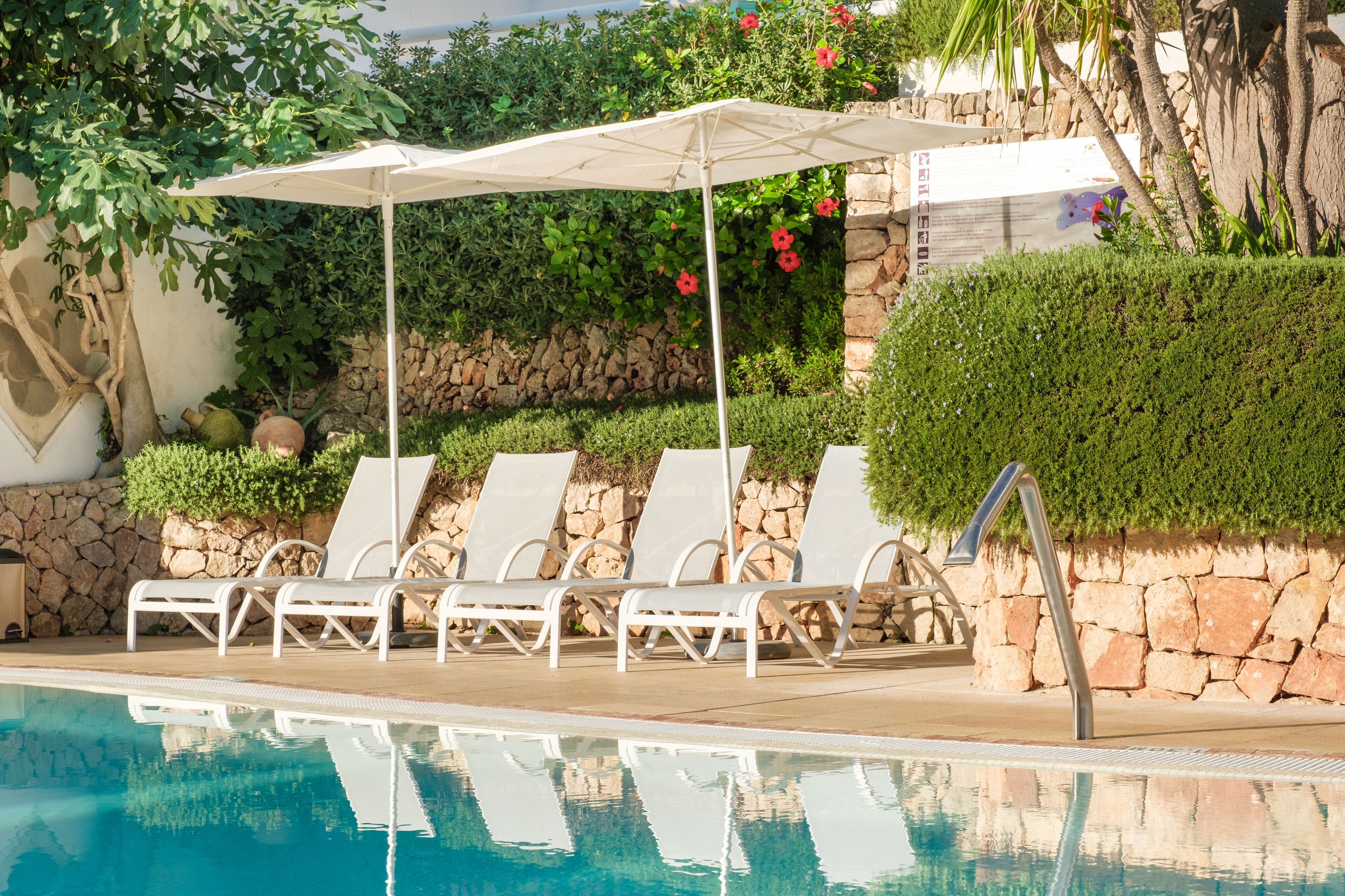 A poolside area with lounge chairs and a canopy.