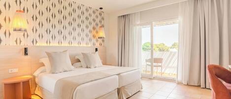 Une chambre d’hôtel avec un lit, une table de chevet, une chaise et une vue sur l’extérieur.